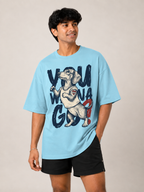 A man wearing a light blue graphic t-shirt with a dachshund and the text 'YOU WILL WIN' on the front, paired with black athletic shorts, against a plain beige background.
